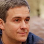 Chris Riley smiling while giving a positive testimonial for Golf Guide Club